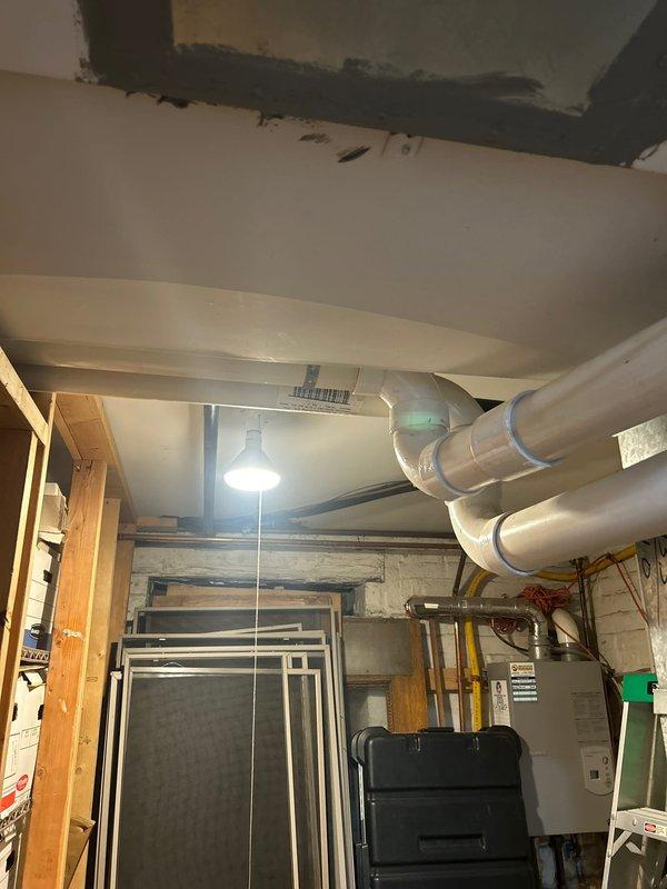 Returned to complete toilet/urinal service requiring two technicians. Installed new PVC drainage pipes with proper elbow joints and secure mounting brackets in utility area. Addressed plumbing infrastructure in basement mechanical room where ventilation system connects to water heater unit. All connections properly secured and tested for functionality.