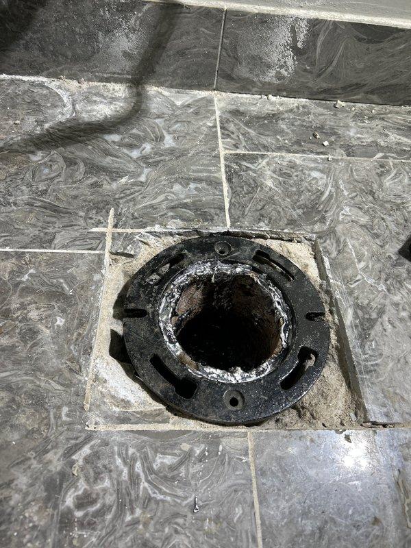 Inspected toilet drainage system and confirmed issue with unlevel flange and pipe causing persistent seal failures. Verified with spirit level that existing flange installation had significant pitch, leading to loose bolts and failed wax seals. Removed toilet, replaced damaged flange assembly and corrected pipe alignment to ensure proper drainage angle and secure mounting surface.