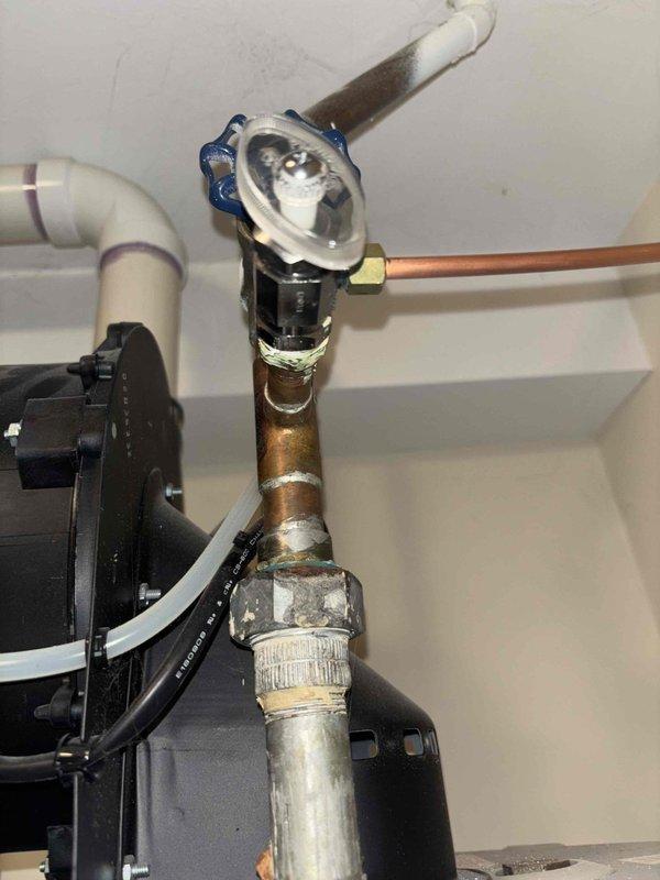 Inspected 17+ year old water heater that customer reported cycles on and off, requiring manual resets. Visual examination revealed significant corrosion at pipe joints, mineral buildup around connection points suggesting previous leakage, and an aging tank system. Recommended replacement due to unit age and intermittent operation issues.