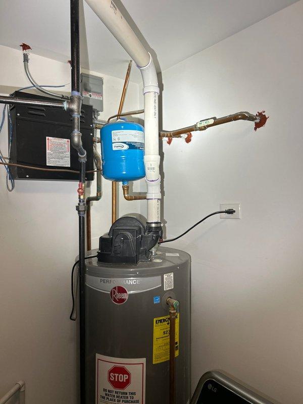 Inspected 50-gallon Rheem Performance water heater (5.5 years old) that was leaking from the base. Documented existing installation setup including expansion tank, pump unit, copper supply lines, and PVC venting system. Recommended replacement due to tank failure.
