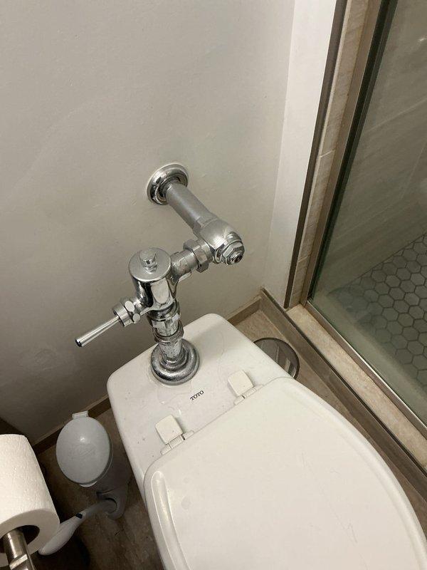 Responded to service call regarding active leaks from shower head and toilet flush handle. Inspected TOTO toilet with chrome flush mechanism and adjacent shower enclosure. Repaired both leak sources, restoring proper function to bathroom fixtures and preventing further water damage to the tiled floor area.