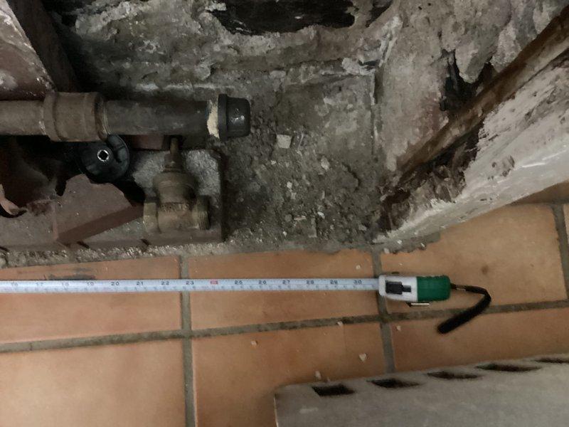 Conducted site assessment for radiator replacement estimate, documenting existing plumbing infrastructure including utility sink fixtures and water supply connections. Measured water service components and evaluated wall deterioration around pipe penetrations to determine scope of work required for comprehensive radiator system upgrade.