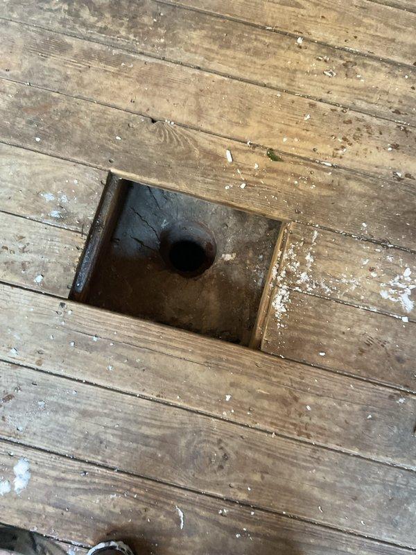 Responded to emergency call regarding sump pump backup causing flooding. Inspected wooden floor access point to sump pump system and examined exterior drainage configuration including downspout connection to drain pipe. Identified aged system with potential blockage issues. Completed necessary repairs to restore proper drainage function and prevent further water intrusion.