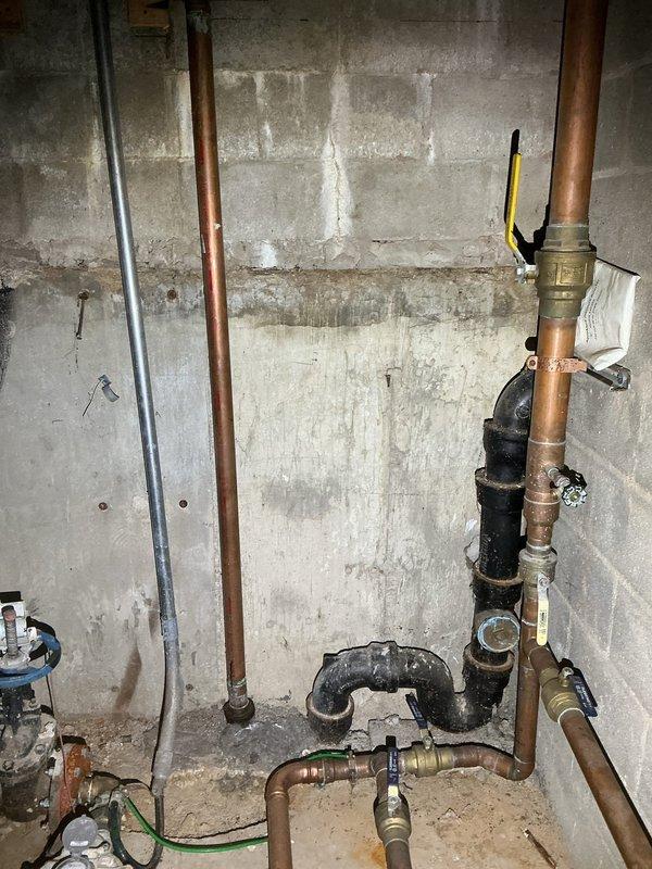 Performed inspection and assessment of existing sewer drain piping infrastructure for commercial building. Documented current plumbing configuration, including copper supply lines and PVC drain assembly. Marked locations with tape for installation of two new cleanouts as requested by client to facilitate proper maintenance and access to the sewer line system.