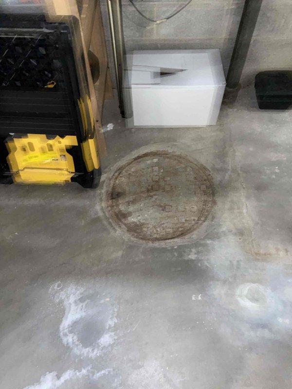 Conducted initial site assessment and photo documentation of basement drainage system and overhead plumbing infrastructure. Scheduled follow-up walkthrough with Kevin Grippo and Flynn to develop comprehensive material list for the upcoming project. Noted existing floor drain condition and ceiling pipe configuration for proper planning purposes.