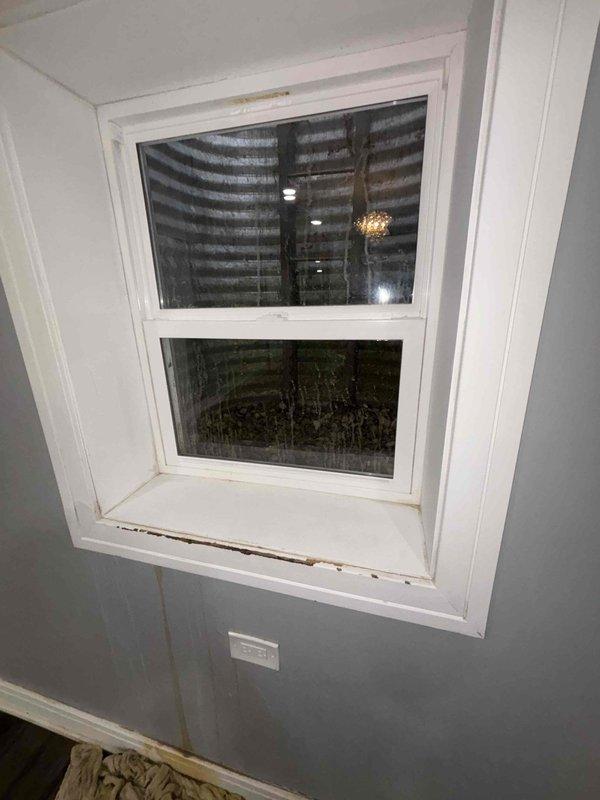 Responded to service callback from Bryan C. Inspected window installation showing signs of wear with discoloration along bottom ledge. Examined water heater system with copper pipes displaying mineral deposits and tarnishing at connection points. Verified proper ventilation through metal vent pipe and confirmed functionality of all components.