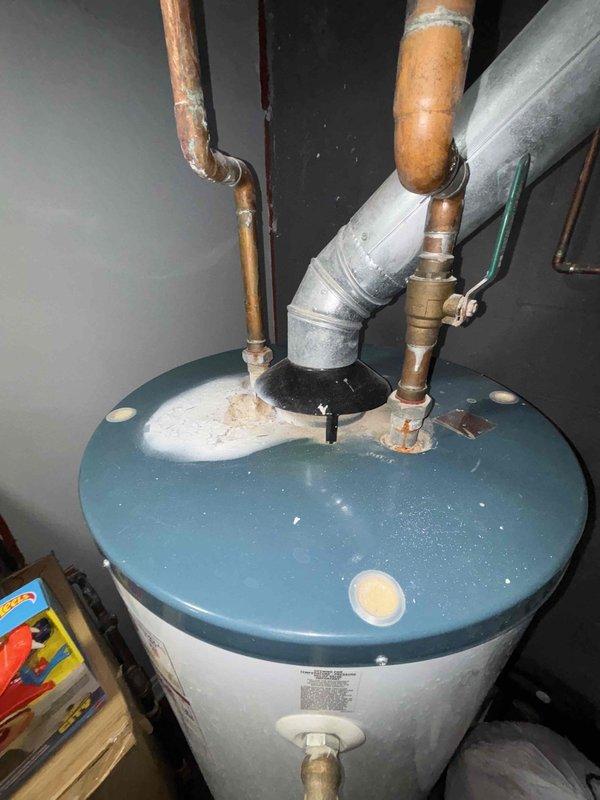 Responded to service callback from Bryan C. Inspected window installation showing signs of wear with discoloration along bottom ledge. Examined water heater system with copper pipes displaying mineral deposits and tarnishing at connection points. Verified proper ventilation through metal vent pipe and confirmed functionality of all components.