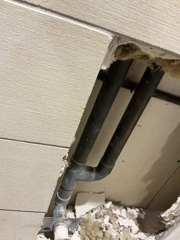 Completed repair work on bathroom plumbing fixture by accessing the wall through tile removal. Exposed and addressed issues with the in-wall plumbing pipes, which showed 90-degree bends requiring service. Repaired the affected plumbing components behind the wall cavity as sold by Brian.