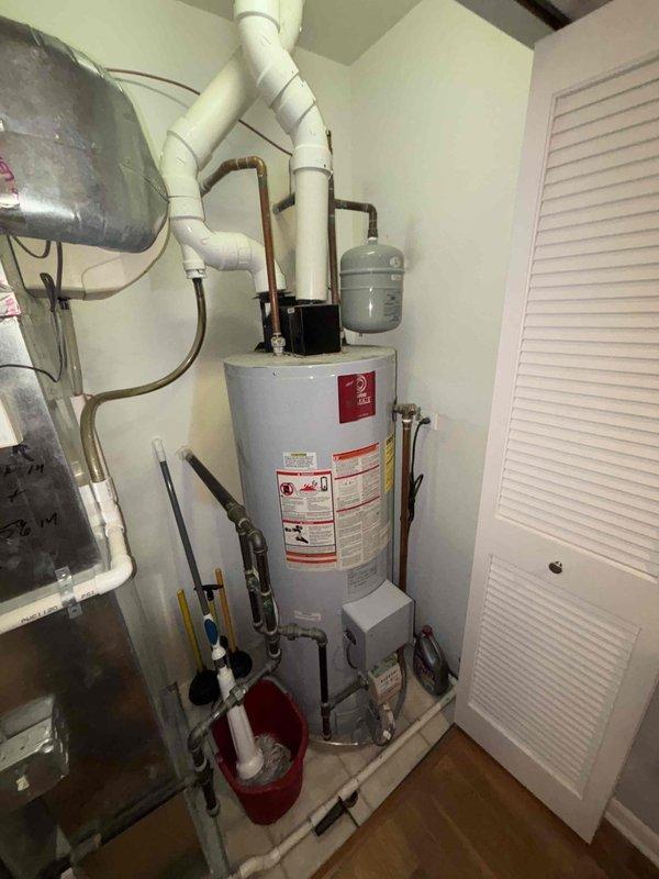 Inspected 19-year-old water heater system exhibiting excessive noise and visible mineral deposits around pipe connections. Visual assessment confirmed significant sediment buildup and corrosion at connection points, consistent with end-of-life system performance. Recommended replacement due to age exceeding typical service life and deteriorating condition.