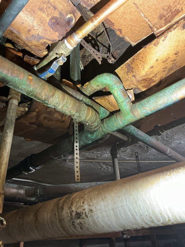 Performed comprehensive sewer evaluation per client's request following previous inspection. Documented significant corrosion and oxidation on copper piping system, particularly on green copper pipe with curved elbow joint. Inspection revealed interior pipe deterioration with substantial rust/sediment buildup and rough texture indicating advanced aging of the system, confirming inspector's recommendation for p-trap installation.