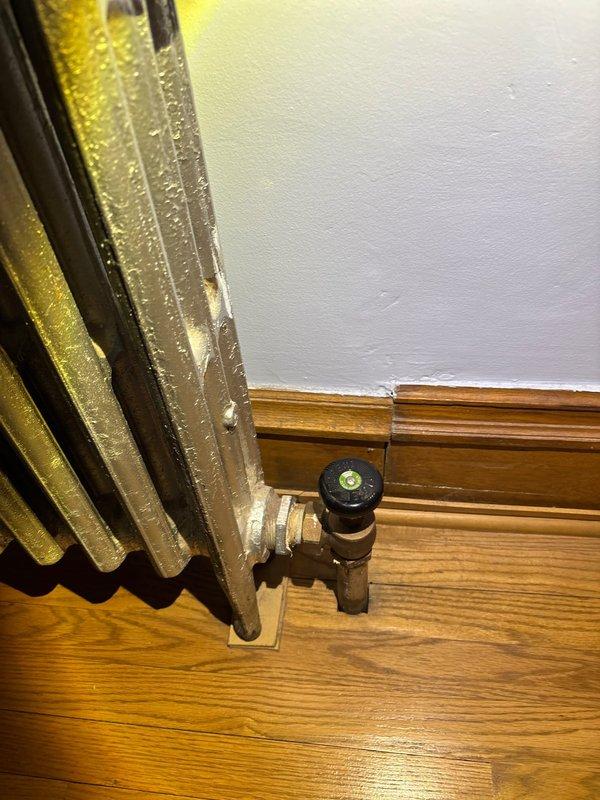 Inspected steam radiator system exhibiting severe banging and hissing noises despite previous valve replacement. Discovered improper air venting causing steam distribution issues and pressure imbalance. Installed appropriately sized air vent valve and adjusted system pressure to optimal levels, significantly reducing noise while maintaining heating efficiency.