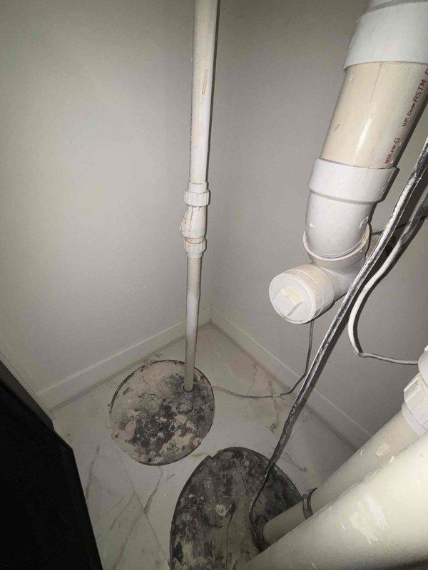 Conducted inspection of existing sump pump system and provided estimate for installation of battery backup system. Observed current drainage setup including floor drains and PVC discharge plumbing. Evaluated water heater proximity and existing utility connections to determine optimal battery backup placement and integration requirements.