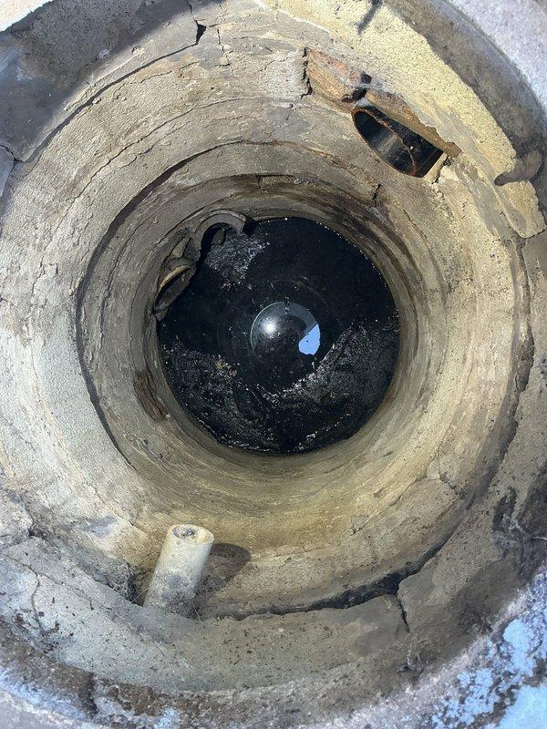Conducted inspection of residential sewer system for VIP customer reporting compromised sewer line. Visual assessment revealed deteriorated concrete access shaft with multiple cracks, structural damage, and standing water at bottom. Basement inspection showed PVC drain configuration with possible previous water damage evidenced by floor staining near drain area.