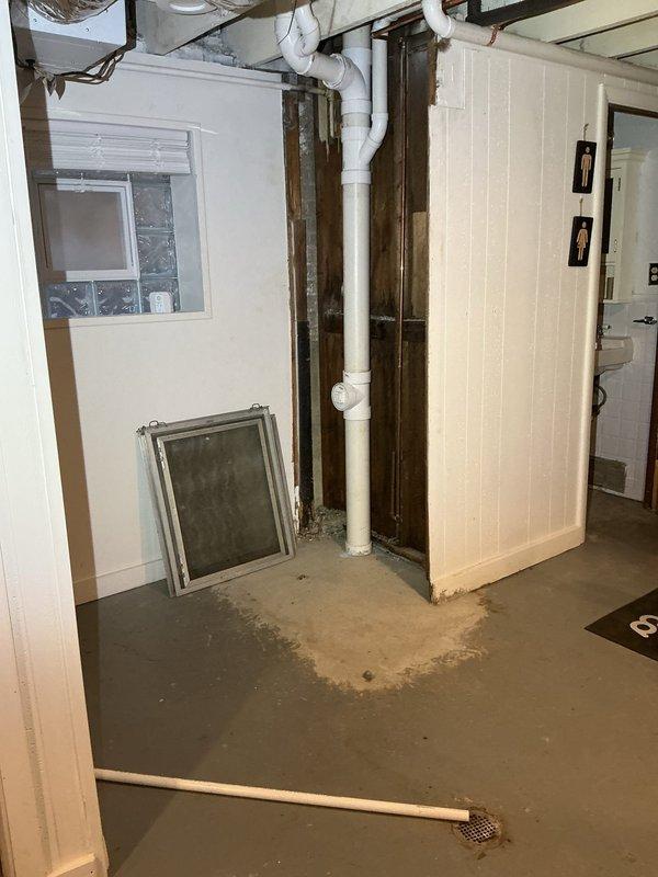 Conducted inspection of residential sewer system for VIP customer reporting compromised sewer line. Visual assessment revealed deteriorated concrete access shaft with multiple cracks, structural damage, and standing water at bottom. Basement inspection showed PVC drain configuration with possible previous water damage evidenced by floor staining near drain area.