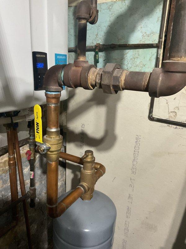Responded to an emergency service call for a non-operational 7-year-old tankless water heater. Inspected the plumbing infrastructure including copper and brass pipe assembly, pressure regulator valve, and multiple shut-off valves. Diagnosed and repaired the system, restoring proper functionality to the tankless unit with digital control panel.