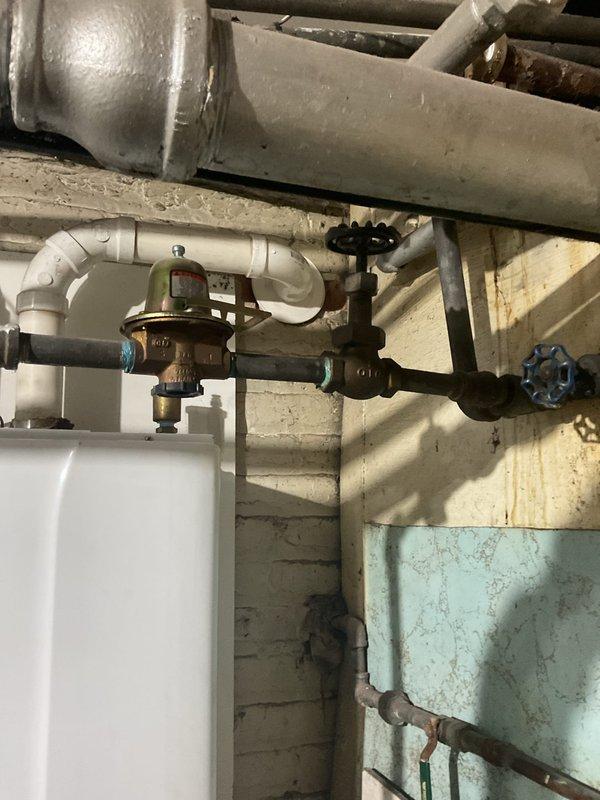 Responded to an emergency service call for a non-operational 7-year-old tankless water heater. Inspected the plumbing infrastructure including copper and brass pipe assembly, pressure regulator valve, and multiple shut-off valves. Diagnosed and repaired the system, restoring proper functionality to the tankless unit with digital control panel.