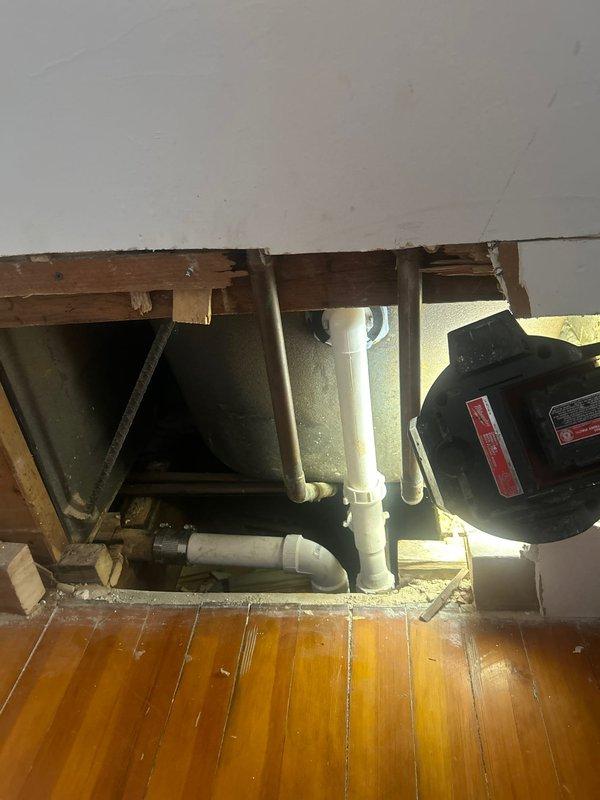 Responded to service call for slow-draining kitchen sink and bathtub. Inspected PVC drainage system in crawlspace, finding significant buildup causing restricted flow. Accessed additional plumbing components through wall opening to locate and clear blockage. Successfully restored normal drainage function to both fixtures.