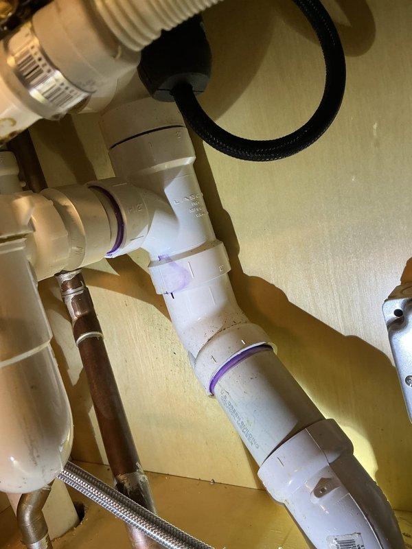 Successfully installed customer-supplied garbage disposal unit. Completed plumbing connections including PVC drain assembly with proper T-joints and P-trap configuration. Verified all connections for leaks and confirmed proper operation of the new disposal system.