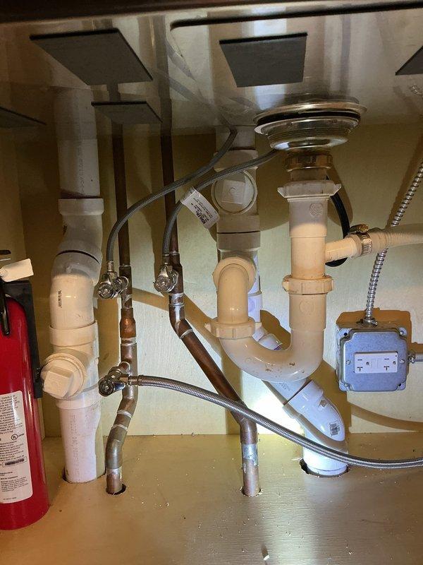 Successfully installed customer-supplied garbage disposal unit. Completed plumbing connections including PVC drain assembly with proper T-joints and P-trap configuration. Verified all connections for leaks and confirmed proper operation of the new disposal system.
