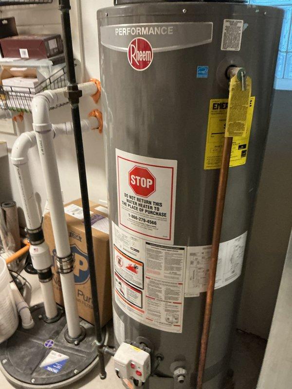 Completed water heater replacement in basement utility area, installing a new Rheem Performance unit with proper PVC venting and copper piping connections. System was tested and verified to be functioning correctly with no leaks observed at connection points.