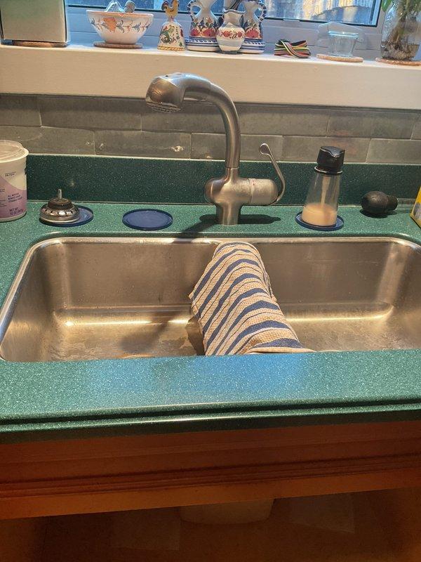 Responded to leak report at kitchen sink. Visual inspection revealed water leakage from P-trap assembly connecting to PVC drain pipes. Installed temporary catch container beneath affected area to prevent water damage while repairs were conducted. Completed replacement of deteriorated P-trap connection, ensuring proper seal and alignment with existing drain system.