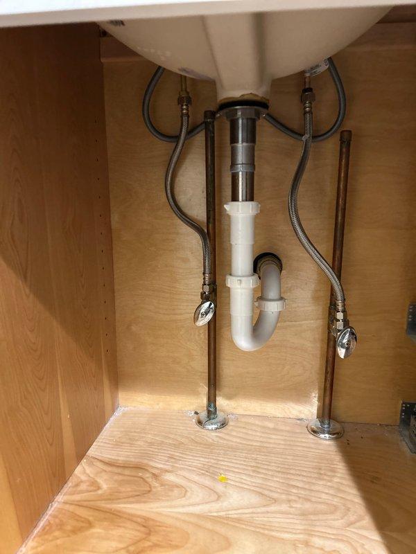 Responded to service call regarding non-functioning garbage disposal. Completed thorough inspection of under-sink plumbing system, examining both the P-trap drain assembly and water supply lines. Verified all connections were secure with no visible leaks or damage to the PVC drain pipes or braided stainless steel supply lines. Resolved garbage disposal issue and confirmed proper operation of all sink components.
