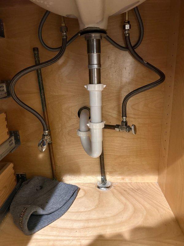 Responded to service call regarding non-functioning garbage disposal. Completed thorough inspection of under-sink plumbing system, examining both the P-trap drain assembly and water supply lines. Verified all connections were secure with no visible leaks or damage to the PVC drain pipes or braided stainless steel supply lines. Resolved garbage disposal issue and confirmed proper operation of all sink components.