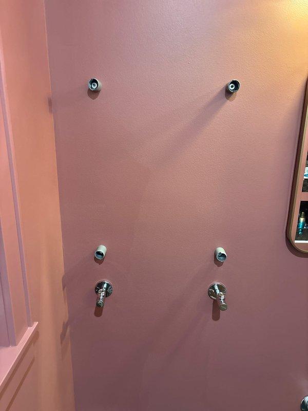 Completed installation of new copper plumbing line with connections to existing PVC supply lines for bathroom shower system. Successfully connected and tested six chrome fixtures including dual shower heads, middle water outlets, and control handles on salmon-colored bathroom wall as part of previously sold repair job. Parts were installed as ordered per original service agreement.