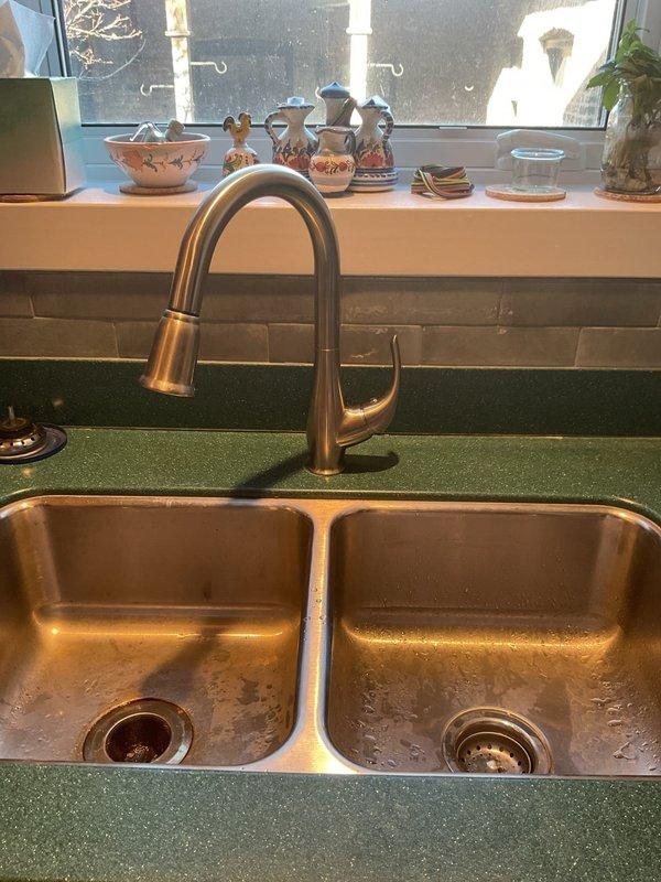 Successfully installed new brushed nickel pull-down faucet on double-basin stainless steel kitchen sink. Connected and secured all braided stainless steel supply lines to existing plumbing system. Verified proper operation and ensured no leaks at connection points.