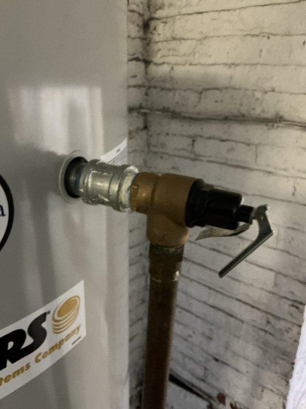 Completed installation of copper pipe with 90-degree elbow joint connecting to water heater system. Installed brass valve fitting on vertical copper line and ensured proper connection to horizontal supply line. All connections tested and verified leak-free with system functioning as designed.