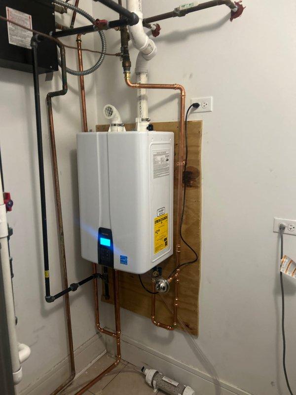 Successfully installed a new tankless water heater in client's utility area, mounting the unit securely on a wooden backing board. Completed all necessary copper pipe connections with proper fittings and valves, and ensured the system was fully operational with no leaks upon final inspection.