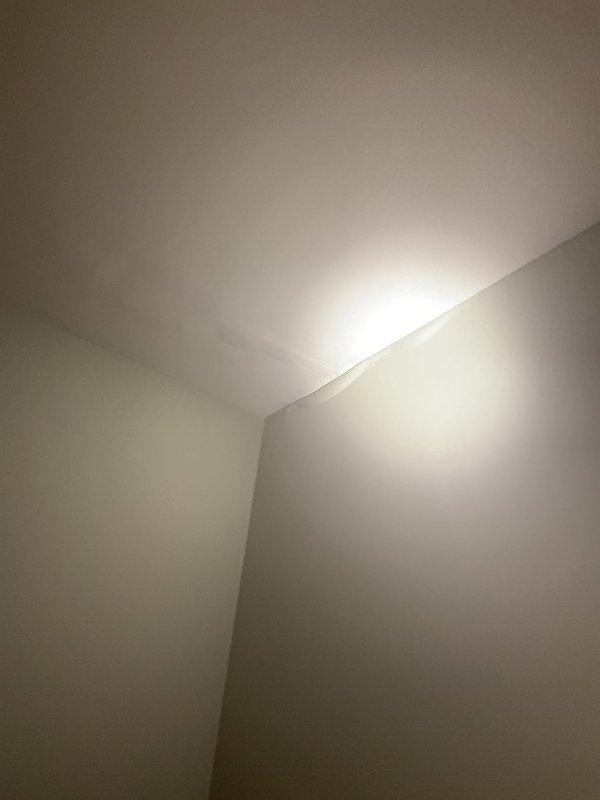 Conducted inspection of reported water intrusion from Unit 2 into Unit 1, where toilet overflow from upstairs bathroom was affecting bedroom below. Visual examination of ceiling and wall junction showed no visible water damage in affected areas. Suspected possible concealed pipe issue causing significant water penetration beyond visible toilet overflow. Recommended further investigation to locate potential burst pipe.