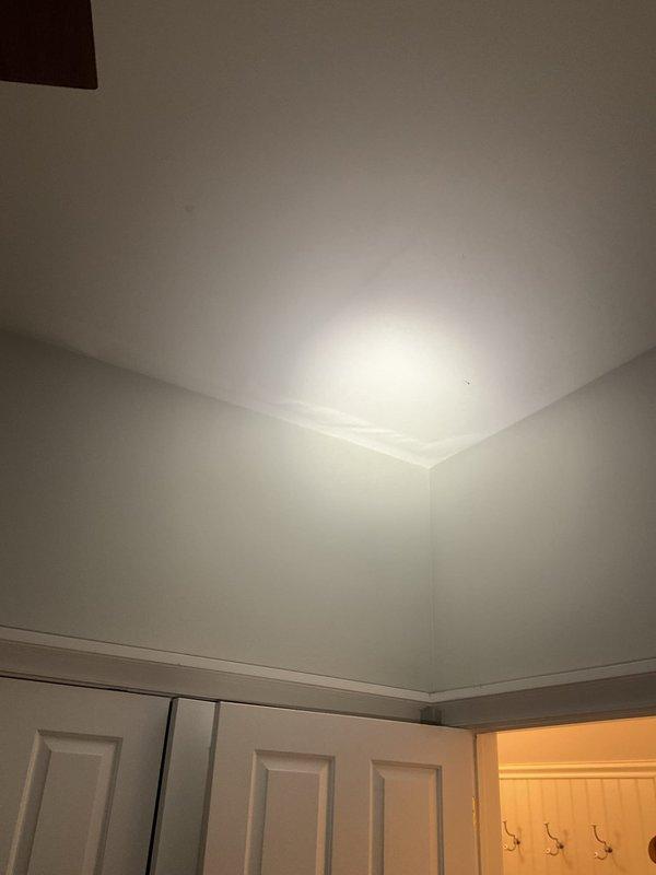 Conducted inspection of reported water intrusion from Unit 2 into Unit 1, where toilet overflow from upstairs bathroom was affecting bedroom below. Visual examination of ceiling and wall junction showed no visible water damage in affected areas. Suspected possible concealed pipe issue causing significant water penetration beyond visible toilet overflow. Recommended further investigation to locate potential burst pipe.