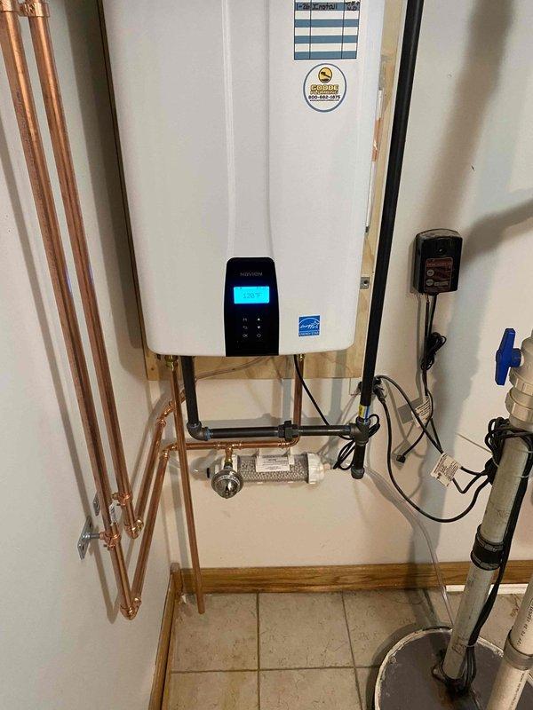 Installed new tankless water heater system with Energy Star certification, replacing corroded copper pipe infrastructure. Connected unit to existing plumbing, installed water filtration component with appropriate insulation, and set up pressure regulation system with control valve. System was tested and confirmed operational with digital control panel functioning properly.