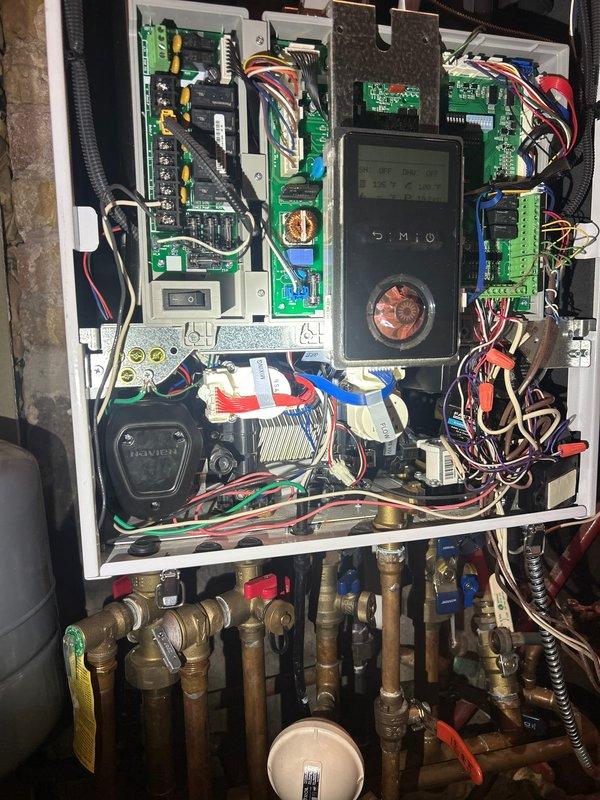 Performed warranty inspection on Combi-Boiler system, identifying faulty flat plate and pressure sensor (system displaying 243 psi). Documented control panel condition with photos and confirmed replacement parts are en route. Customer informed that warranty service will be scheduled upon parts arrival.