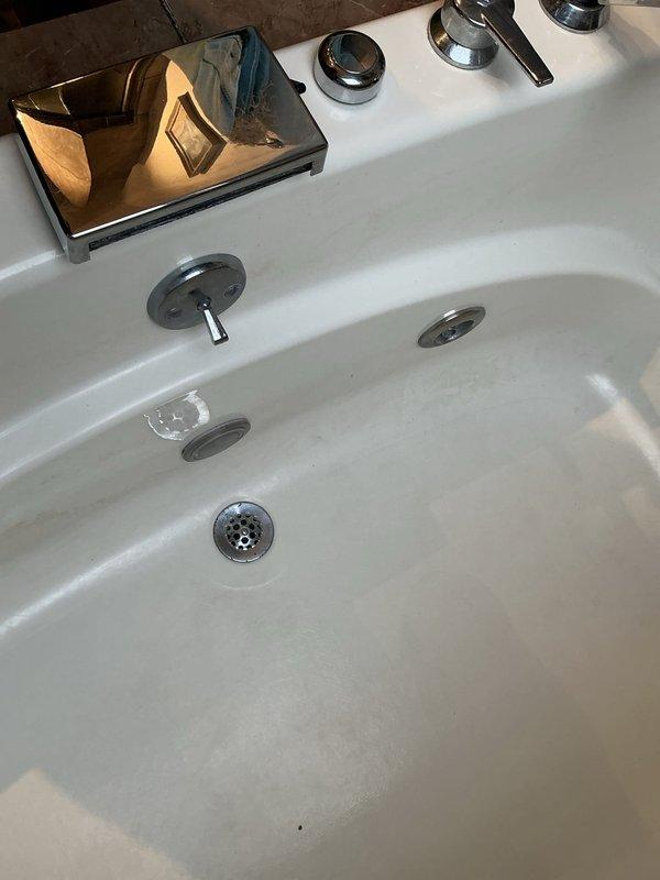 Performed follow-up inspection on bathroom fixtures. Documented chrome faucet handles installed on stone countertop and white porcelain sink with metal drain. Project on hold pending tile removal by separate contractor.