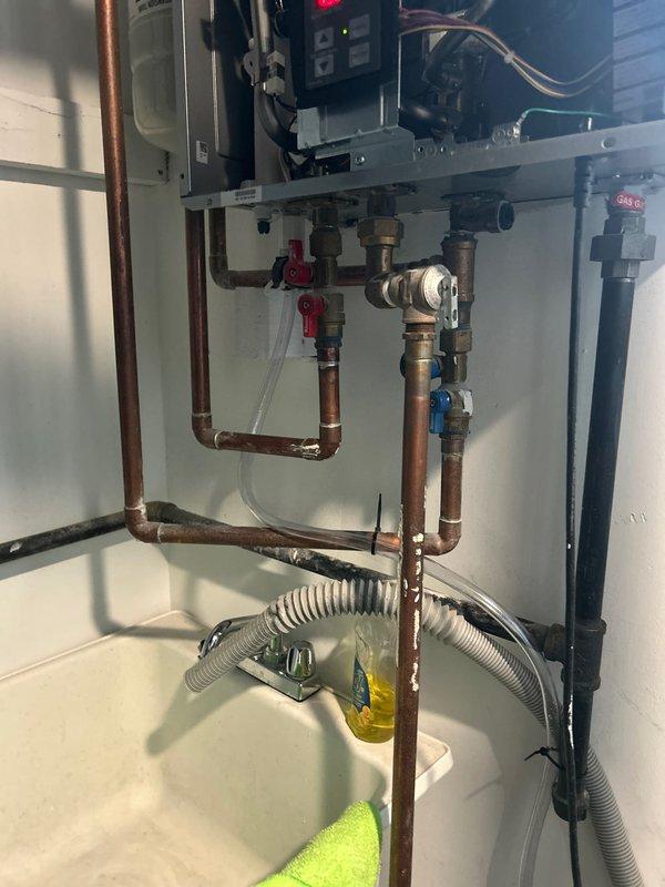 Responded to service call for a 3-year-old tankless water heater not producing hot water. Diagnosed scale buildup in the heat exchanger causing reduced flow and thermal efficiency. Performed descaling procedure using vinegar solution, cleaned inlet filter, and verified proper operation of temperature sensors. System now functioning correctly with consistent hot water output and normal operating parameters.