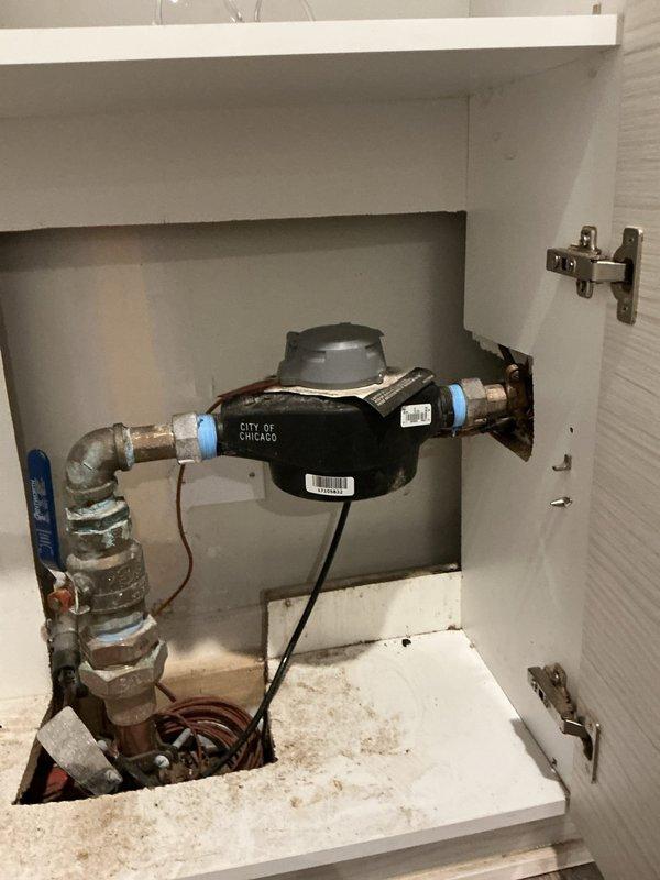 Responded to service call for frozen pipes resulting in no water flow. Inspected the City of Chicago water meter installation and associated plumbing components. Located and verified operation of the main shutoff valve with blue handle, then performed necessary thawing procedures to restore water service to the property.
