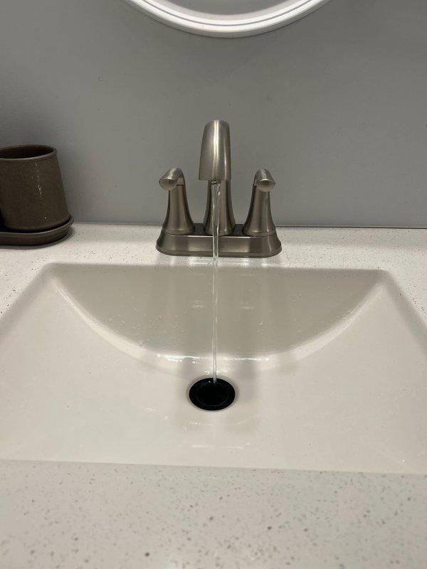 Responded to a call regarding frozen pipes. Upon inspection, found no evidence of frozen pipes as both bathroom sinks were functioning properly with normal water flow and drainage. Verified all visible plumbing components were operating correctly and no service was required.