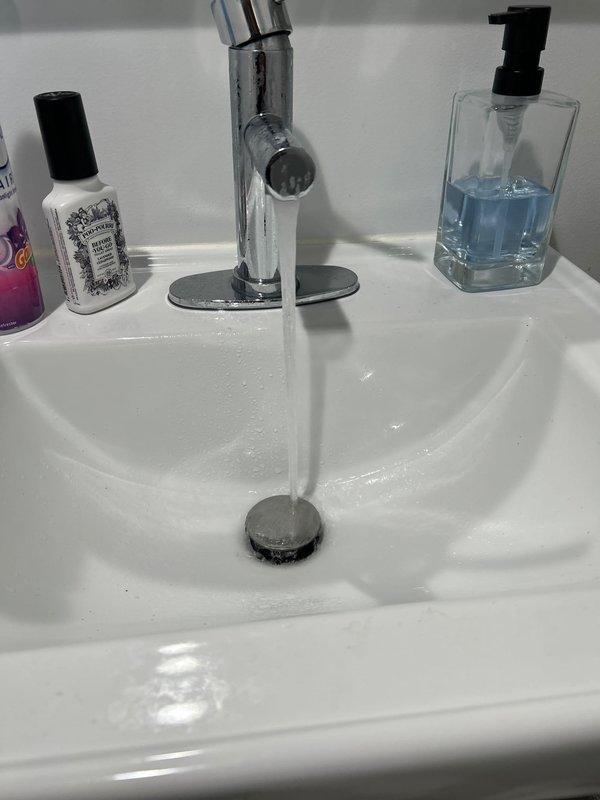 Responded to a call regarding frozen pipes. Upon inspection, found no evidence of frozen pipes as both bathroom sinks were functioning properly with normal water flow and drainage. Verified all visible plumbing components were operating correctly and no service was required.