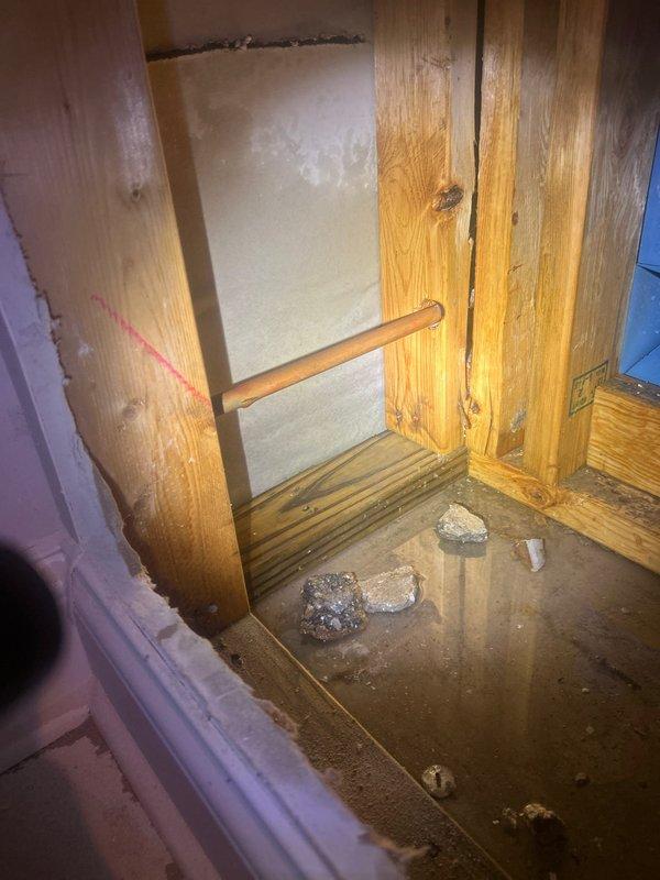 Responded to emergency call regarding frozen pipe behind toilet. Upon inspection, discovered water intrusion with approximately 1" of standing water at the base of the wall. Created access point in wall to expose affected copper supply line with visible frost damage. Thawed pipe, verified proper water flow, and inspected for leaks before recommending additional insulation for exposed plumbing in this area to prevent future freezing issues.