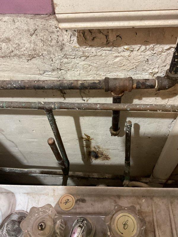 Responded to emergency call for burst pipe in basement. Upon inspection, found significant aging and corrosion in existing metal plumbing system with visible water damage to surrounding wall. Replaced damaged section with new copper piping, installed brass valve fitting for improved flow control, and secured all connections. Verified system integrity with pressure test; no leaks detected.
