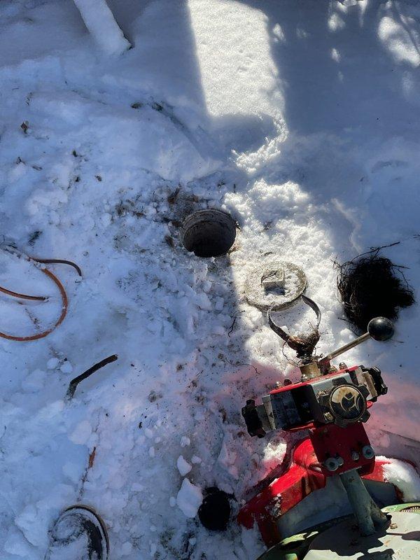 Responded to service call for basement drain backup caused by root intrusion. Accessed the drain system through exterior cleanout point (visible in snowy conditions) and utilized mechanical drain cleaning equipment to clear root blockage. Successfully restored proper drainage function in the basement plumbing system.