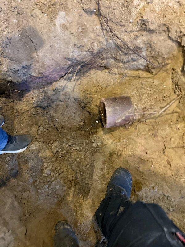 Excavated area to access damaged clay sewer pipe showing signs of deterioration with visible black residue and water damage. Job was sold by Jon Hartman and scheduled for Monday with Mikey's approval, no down payment required.