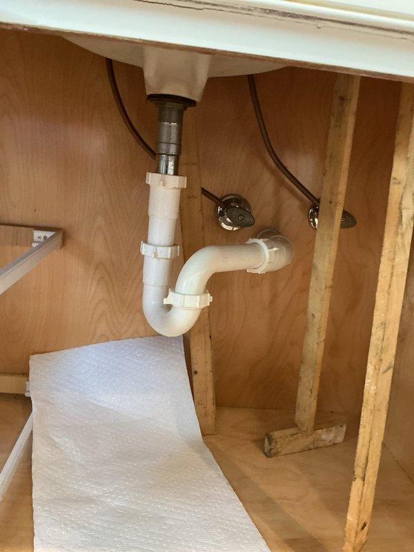 Responded to service call for a bathroom sink with reported gap between sink and vanity due to seal issue. Upon inspection, examined the P-trap assembly, water supply lines, and mounting bracket securing the plumbing components. Verified proper connection of drain pipe to wall and checked compression fittings throughout the system. Completed repair by resealing sink-to-vanity connection, ensuring proper alignment and watertight seal.