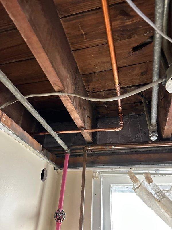 Responded to customer report of water leak in basement. Upon inspection, observed water seepage coming from copper supply line in exposed ceiling area. Identified pinhole leak at joint connection where copper pipe meets valve assembly. Repaired compromised section by replacing damaged pipe segment and installed new soldered joint fitting. Pressure tested system to confirm successful repair with no further leakage detected.