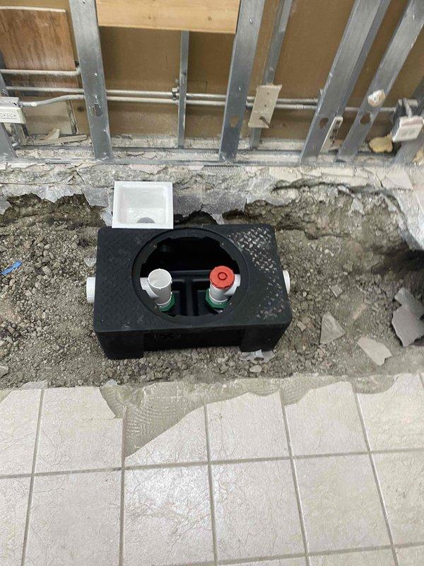 Completed installation of new water supply valves with access box in concrete floor. Demolished existing tile and concrete to properly set recessed valve box with dual shut-off controls. Installation included proper framing support and connection to existing wall-mounted supply lines.