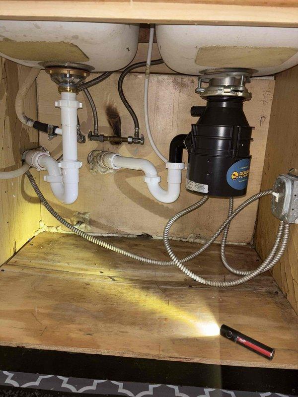 Replaced non-functioning garbage disposal unit in kitchen sink. Removed corroded metal connections and installed new unit with proper PVC drain piping. Tested system for proper operation and verified no leaks at connection points.