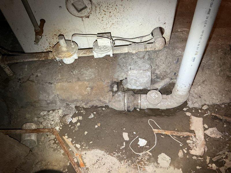 Performed comprehensive assessment of commercial plumbing system requiring multiple repairs. Evaluated failing sump pump requiring replacement, identified deteriorated PVC drainage pipes with mineral deposits and leakage issues. Documented necessary repairs including reconfiguration of kitchen P-trap, correction of women's bathroom hot water valve malfunction, and sealing of leaking ground drainage pipe connection.