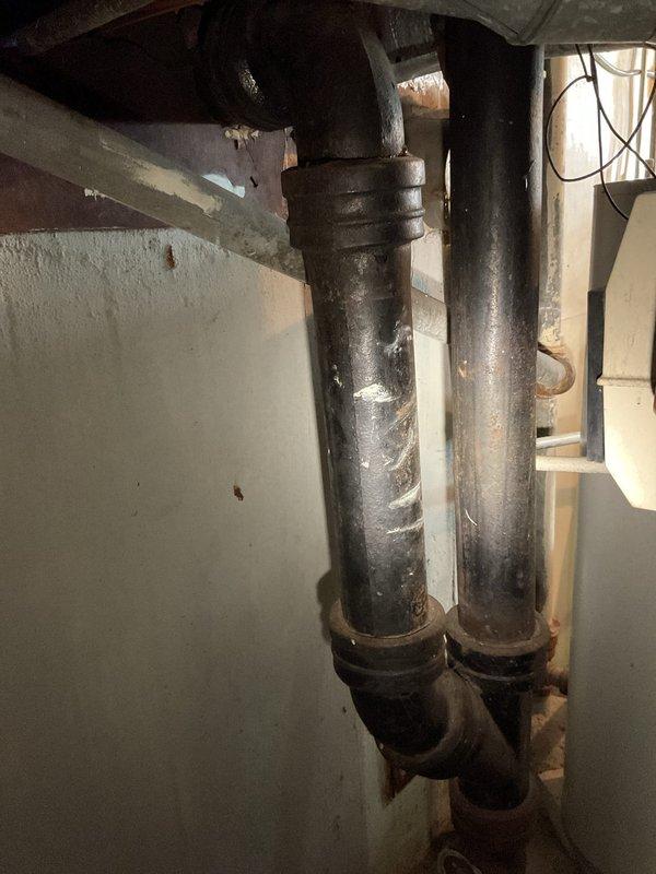 Inspected basement ejector pump system due to reported discharge issues. Examined vertical waste pipes for integrity and proper function. Identified pump malfunction causing waste backflow into basement. Documented condition of PVC vent pipe and associated drainage components for repair assessment.
